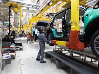 Car bodies are on assembly line. Factory for production of cars. Modern automotive industry. A car being checked before being painted in a high-tech enterprise.